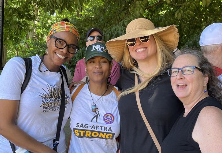Four women stand side by side smiling at the camera.