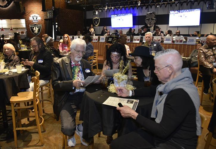 Members sit at tables and study their SAG Awards scorecards.