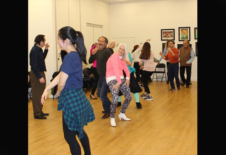 Un grupo diverso de hombres y mujeres bailan a lo largo de la línea del Soul Train.