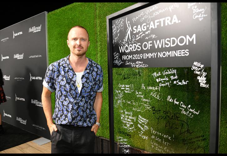 Aaron Paul is casual and cool next to the SAG-AFTRA Words of Wisdom wall.