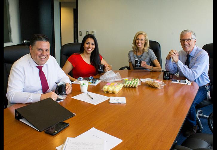 AG-AFTRA members from WJLA/NC8 sit around a table with sweets, their CBA and union swag.