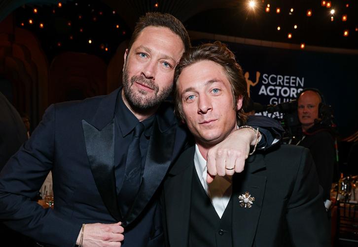 Ebon Moss-Bachrach and Jeremy Allen White on the awards floor. Moss-Bachrach drapes his arm around White's shoulders. 