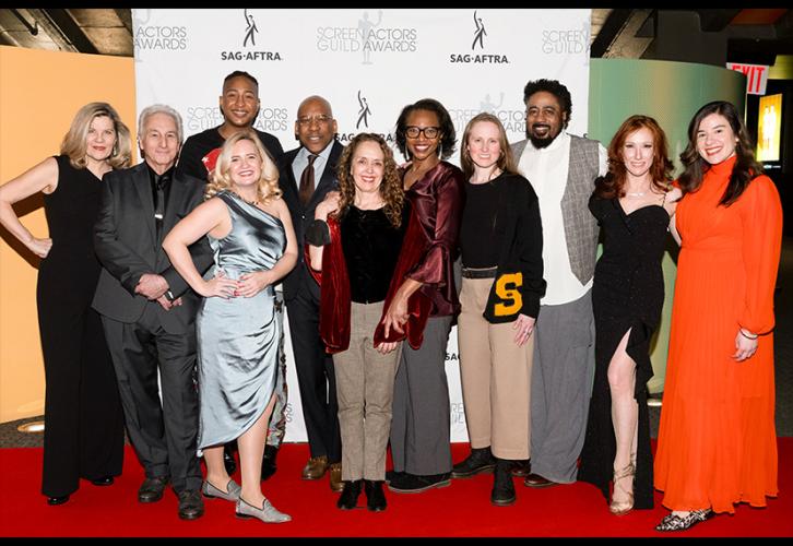 A large, diverse crowd gathers on the red carpet. Behind the group is a white step-and-repeat backdrop with the SAG-AFTRA and SAG Awards logos.