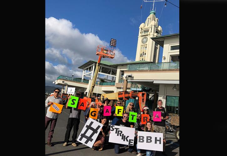 Hawaii Local members with colorful signs at the Aloha Tower on Dec. 13.