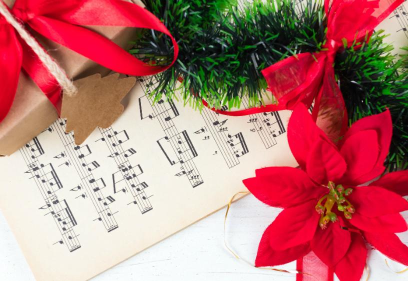 SAG-AFTRA Holiday Caroling 2024 Sheet music and poinsettas.