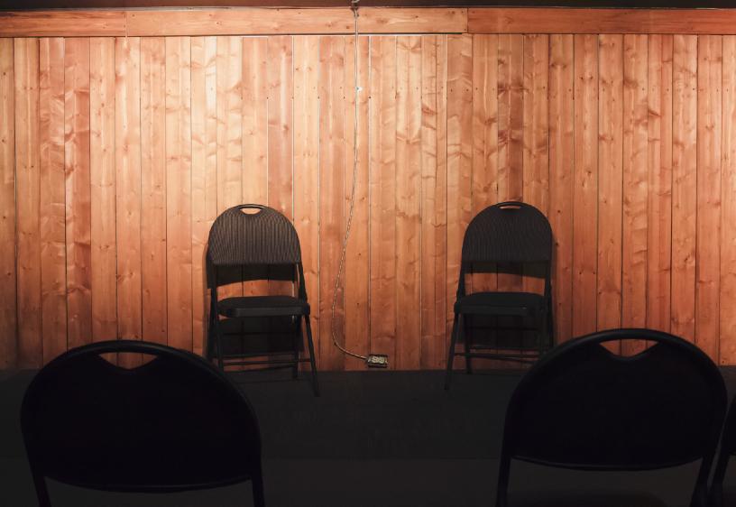 Dos sillas plegables en un escenario.