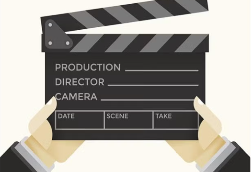 Two hands with black sleeves and a grey undersleeve hold a director's clapboard that is black and gray.