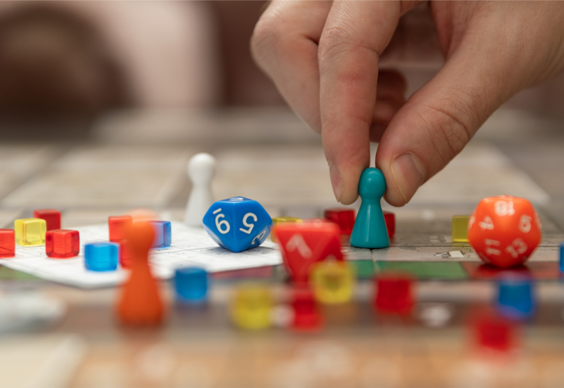 A hand holds a board game piece. 