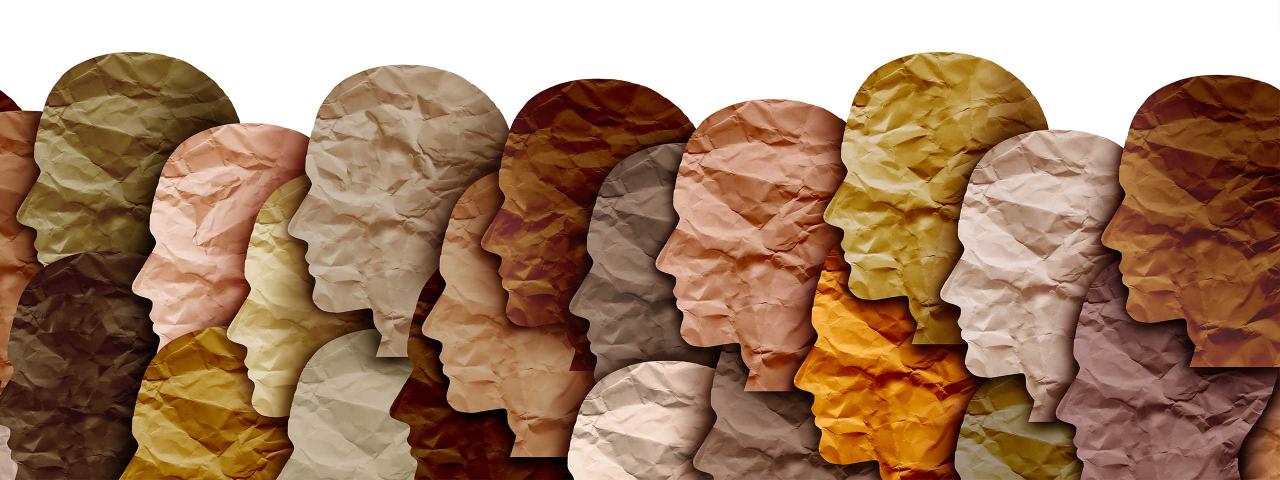 Image of different paper cut out in the shape of human heads, side profile.
