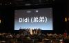 A photo of a crowd in a movie theater. Sixteen individuals stand on stage; Wang, center, wears a black blazer over a T-shirt. Behind them on the projector screen is a title card with the word “Dìdi” and two Chinese characters in white.