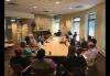 Members of the Twin Cities Local are seated around a table and conversing with one another. Members of the Twin Cities Local are seated around a table and conversing with one another.