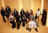 The cast of The Bear, including Chicago members Richard Esteras and Jose Cervantez. The cast of The Bear pose in a yellow room with their award statuettes. Some are seated and some are standing.