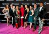 Desde la izquierda, Kaily Smith, Denis Berkfeldt, Nancy Flanagan, Shari Belafonte, Linda Powell, Jodi Long, Randi Kleiner, Sonny G., Golden Goodwin Un grupo de nueve personas bien vestidas se encuentra sobre una alfombra fucsia frente a un telón de fondo con múltiples logotipos de SeriesFest.