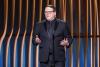 SAG-AFTRA National Executive Director & Chief Negotiator Duncan Crabtree-Ireland stands on stage. He wears an all black outfit.