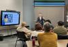 SAG-AFTRA member Ryan Walker teaches Conservatory members how to leverage social media for their acting careers in his hour and a half social media intensive workshop. A man in a blue suit with a white shirt stands teaching a group of men and women in a class setting.
