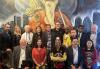 Union leaders pose for a photo The group of union leaders pose against a mural of a city skyline.