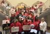 From left, PowHer New York Board Chair Mary Luke, SAG-AFTRA Chief Labor Policy Officer & New York Local Executive Director Rebecca Damon, New York City Council Speaker Adrienne Adams, New York City Council member Amanda Farias, and Communications Workers of America Local 1180 President Gloria Middleton. A diverse group of people wearing red and holding varying signs which read, “Sag-Aftra Strong,” “PowHer,” “Stronger Laws Now! Pay Transparency and Data Reporting,” “#EqualPayNY” are gathered around a staircase.