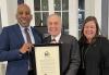 SAG-AFTRA New York Local President Ezra Knight, New York State Comptroller Thomas P. DiNapoli, and SAG-AFTRA Executive Director, New York Local, Labor Policy, and International Affairs Rebecca Damon. Knight, DiNapoli and Damon stand in front of a window, with DiNapoli holding a proclamation.