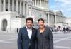 Gomez and Powell stand close together in front of the Capitol building while people mill around in the background. Gomez and Powell at the Capitol