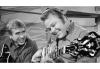 Roy Clark Photo of Roy Clark playing the banjo with Buck Owens holding a guitar and smiling watching Roy play