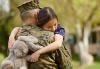 Grant a Wish for Our Heroes Dressed Military personnel carrying a young girl whose arms are wrapped around Military personnel holding a light grey stuffed bunny