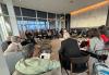 Un gran grupo de personas está sentado en una sala de reuniones de lujo.