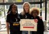 From left, L.A. Local Health Care Safety Net Committee Chair Joyce Guy, alongside committee members Caroline Bielskis and Evelyn Stokes, welcomes donors at the blood drive held at SAG-AFTRA Plaza. Three individuals stand around a silver and white sign with black lettering.