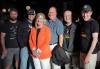 Six inviduals, five men and one woman, in a group photo inside a darkened room. Two men on the far right wear black "SAG-AFTRA Strong T-shirts."