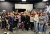 After participating in a workshop about creating self-tapes, participants gathered to take a photo with acting coach and presenter Loren E. Chadima. A group of people gather for a photo in a studio.