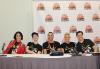 Five people, three women and two men, are seated at a dias. All wear SAG-AFTRA Video Game Strike T-shirts; the woman on the far left wears a bright red jacket and the woman beside her wears a ball cap. Behind them is a step-and-repeat backdrop with the L.A. Comic Con logo.